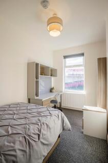 Bright and tidy bedroom featuring a comfortable...