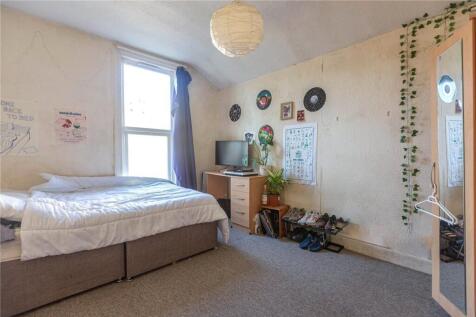 Bright single bedroom featuring a cozy bed with...