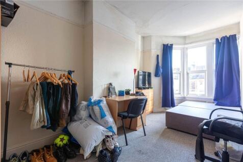 Cozy single bedroom featuring a large bay windo...