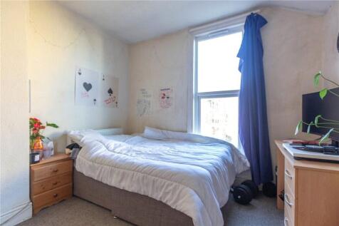 Cozy bedroom featuring a comfortable single bed...