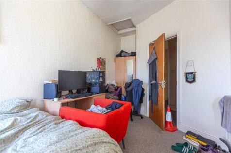 A cozy single bedroom featuring a comfortable b...