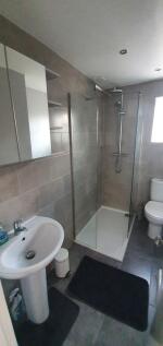 Modern bathroom suite featuring a large walk-in...