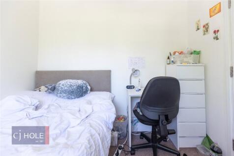 A cozy single bedroom featuring a comfortable b...