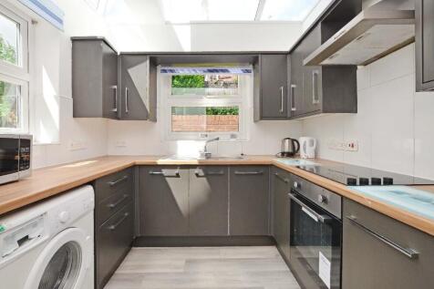 A modern kitchen featuring sleek grey cabinetry...