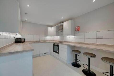 Bright and modern kitchen featuring clean white...