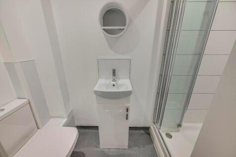 A modern bathroom suite featuring a clean white...