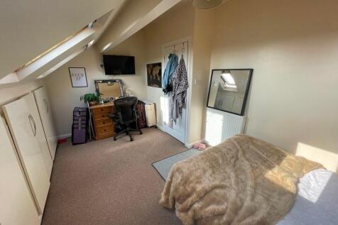 Cozy and bright single bedroom featuring sloped...