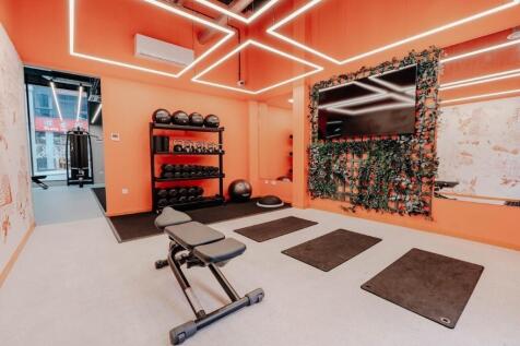 A modern, vibrant gym room featuring bright ora...