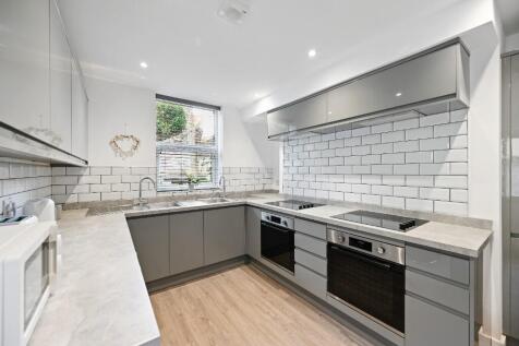 Modern kitchen featuring sleek grey cabinetry w...