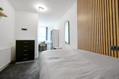 A modern and clean single bedroom featuring a c...