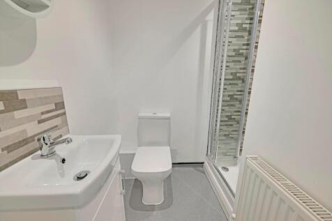 Bright and modern bathroom suite featuring a sl...