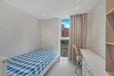 A tidy single bedroom featuring a comfortable b...