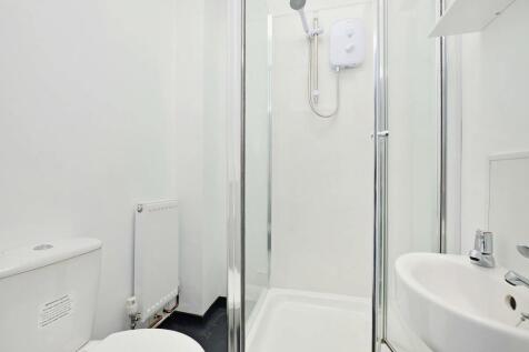 A clean and modern bathroom featuring a glass-e...