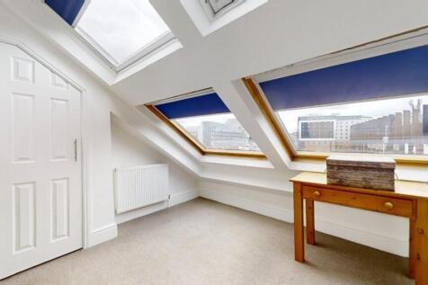 A bright and airy master bedroom featuring larg...