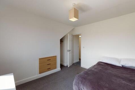 A neat and well-lit double bedroom featuring a ...