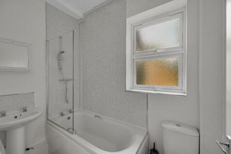 A clean and bright bathroom suite featuring a b...