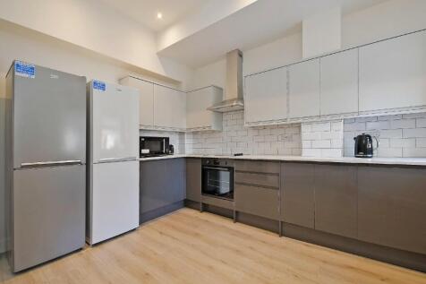 Modern kitchen with sleek grey cabinetry, two l...