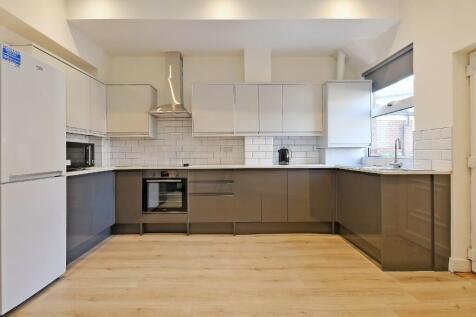Bright and modern kitchen featuring sleek cabin...