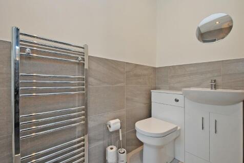 A modern bathroom suite featuring a sleek white...
