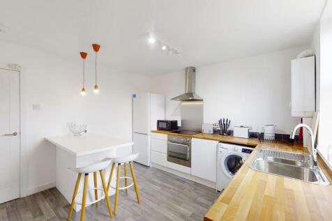 A bright and modern kitchen featuring clean whi...