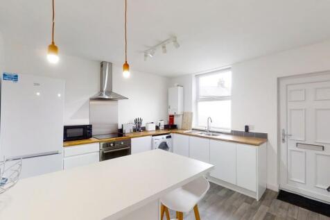 Bright and modern kitchen featuring white cabin...