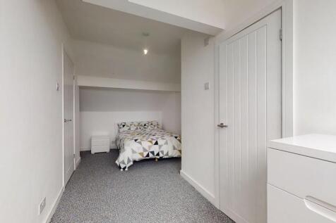 A clean and simple single bedroom featuring a c...
