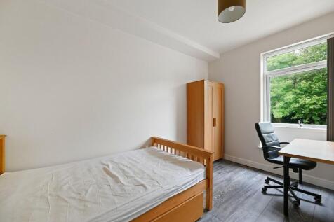 A bright and tidy single bedroom featuring a wo...