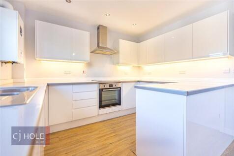 Bright modern kitchen featuring sleek white cab...
