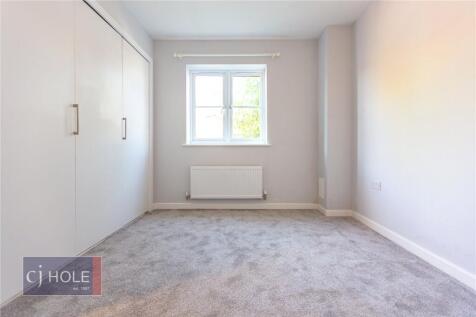 A bright, clean double bedroom featuring soft c...