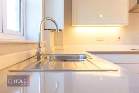 Bright and modern kitchen featuring sleek white...