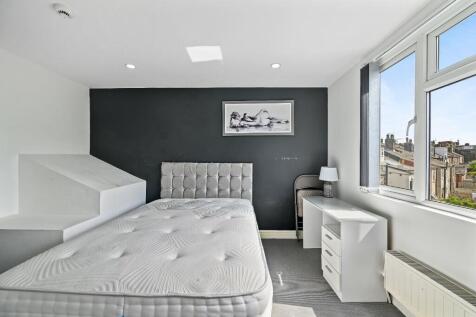 Bright and modern master bedroom featuring a co...