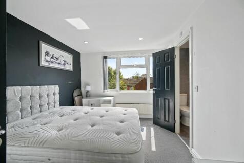 Bright and airy master bedroom featuring a larg...