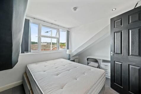 Bright double bedroom featuring a large window ...