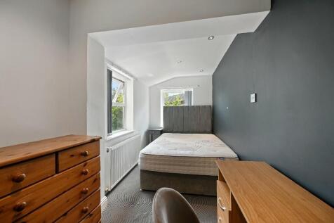 A bright and tidy double bedroom featuring a co...