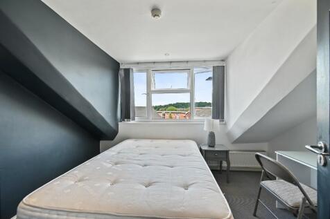 Cozy single bedroom with a large window offerin...