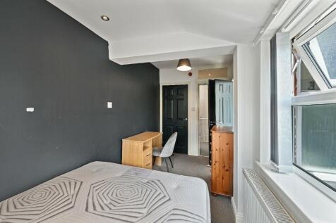 A neatly arranged single bedroom featuring a co...