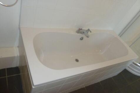 A clean and modern bathroom suite featuring a s...