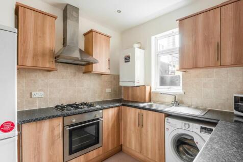 Bright and modern kitchen featuring wooden cabi...