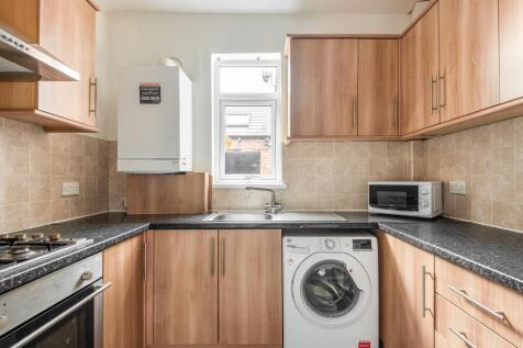 Bright and tidy kitchen featuring modern wood c...