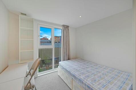 A neat and well-lit single bedroom featuring a ...