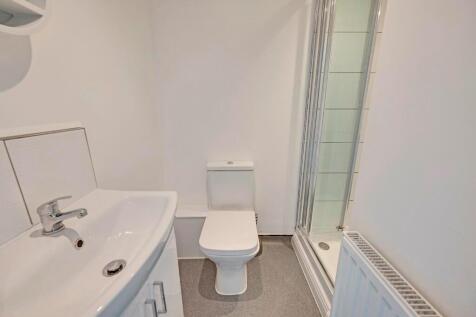 A clean, modern bathroom featuring a white sink...