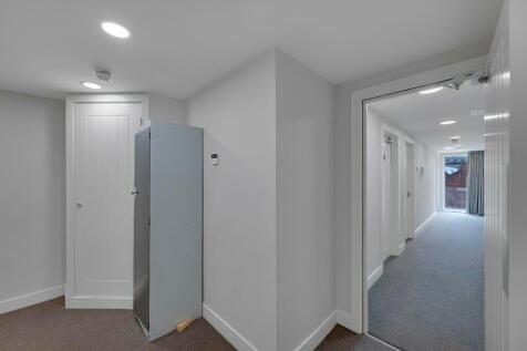 Bright and tidy hallway with clean white walls ...