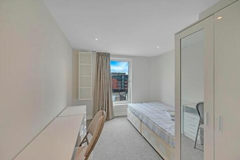 A bright, neatly arranged single bedroom featur...