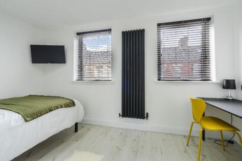 Bright and modern double bedroom featuring larg...