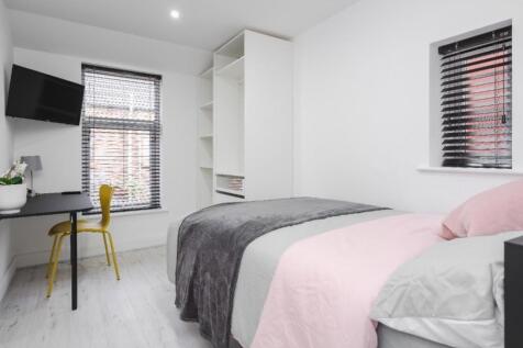 This stylish double bedroom features a cozy des...