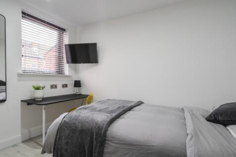 This stylish double bedroom features a cozy atm...