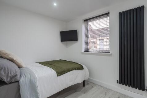 This inviting double bedroom features a cozy la...