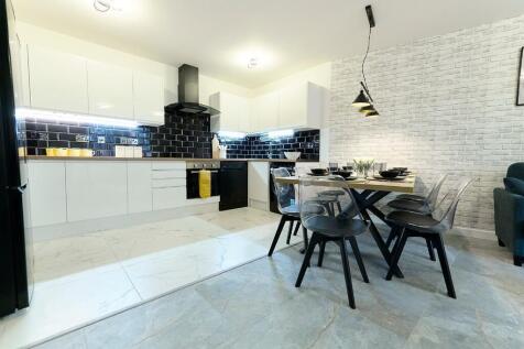 A modern, sleek kitchen and dining area featuri...