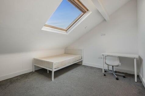Bright and cozy single bedroom featuring a mode...