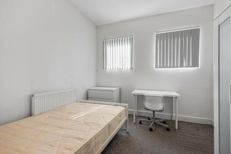 A neat and well-lit single bedroom featuring a ...